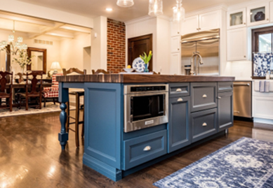Image of a blue kitchen island with a butcher block worktop, sink, and microwave.