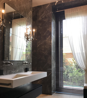 Image of a modern bathroom with a marble backsplash, slab countertop, and a wheelchair accessible sink.