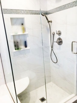 Renovated Bathroom Shower with Glass Surround and Stainless-Steel Fixtures
